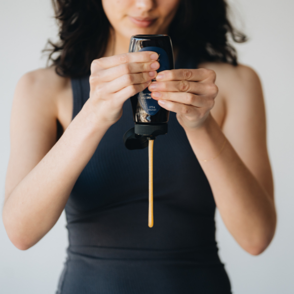 Woman squeezing a container of honey